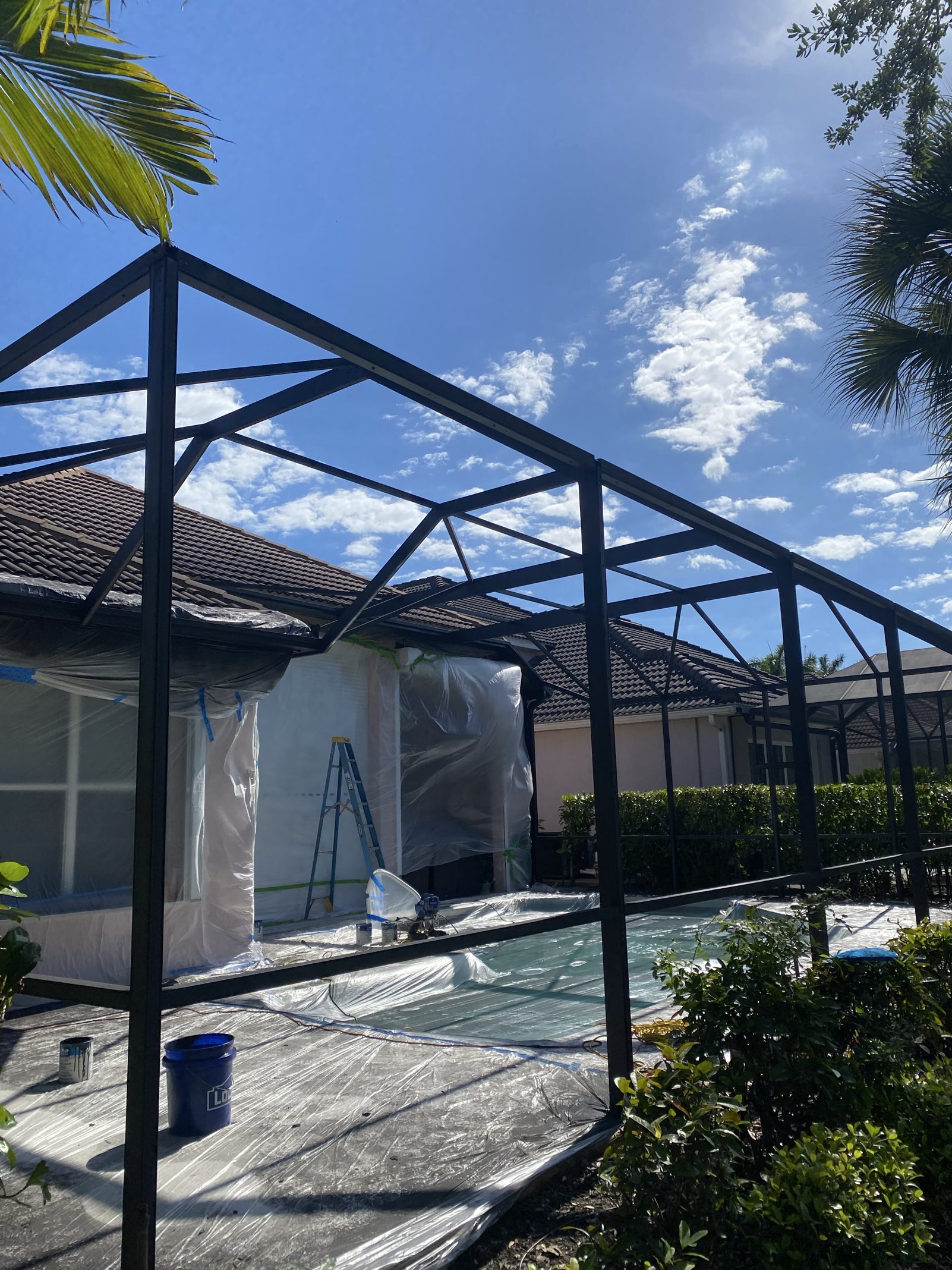 Riley masking and prepping a pool cage frame for a Sherwin-Williams DTM paint job