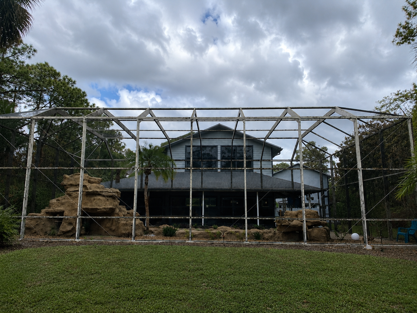 Faded, unscreened pool cage frame before restoration