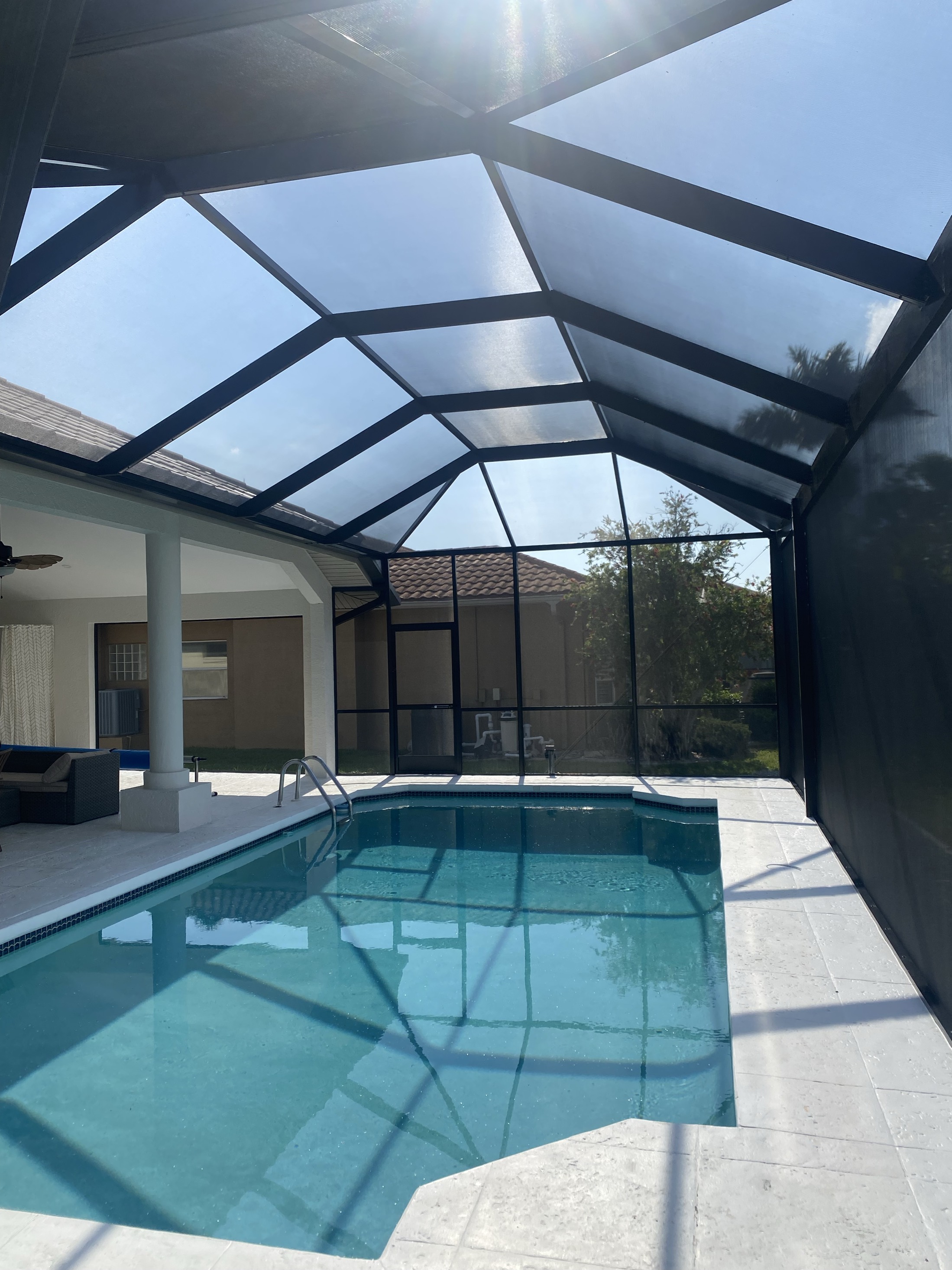 Freshly restored black-framed pool cage enclosure in Southwest Florida